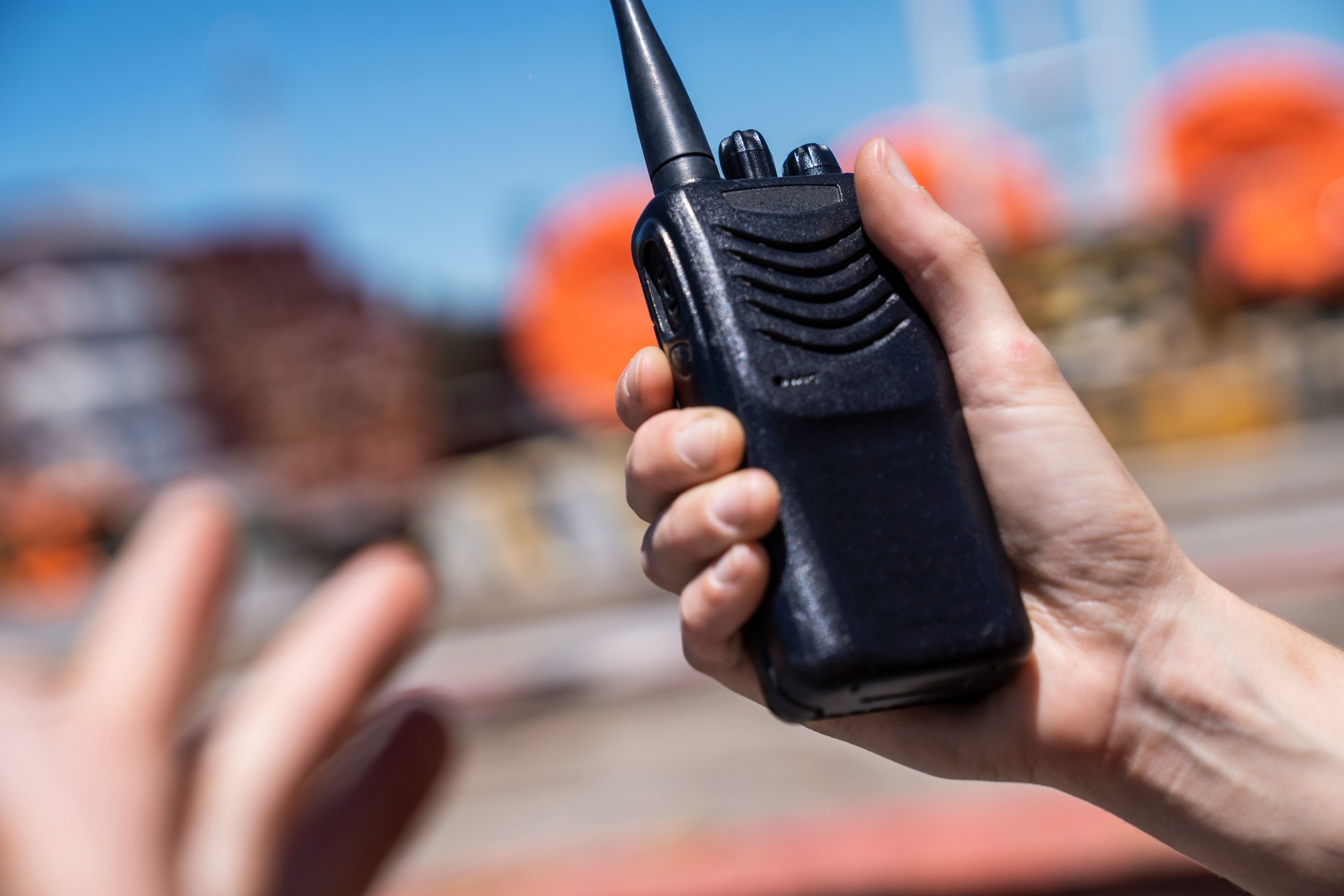 Midsection of man holding walkier talkier