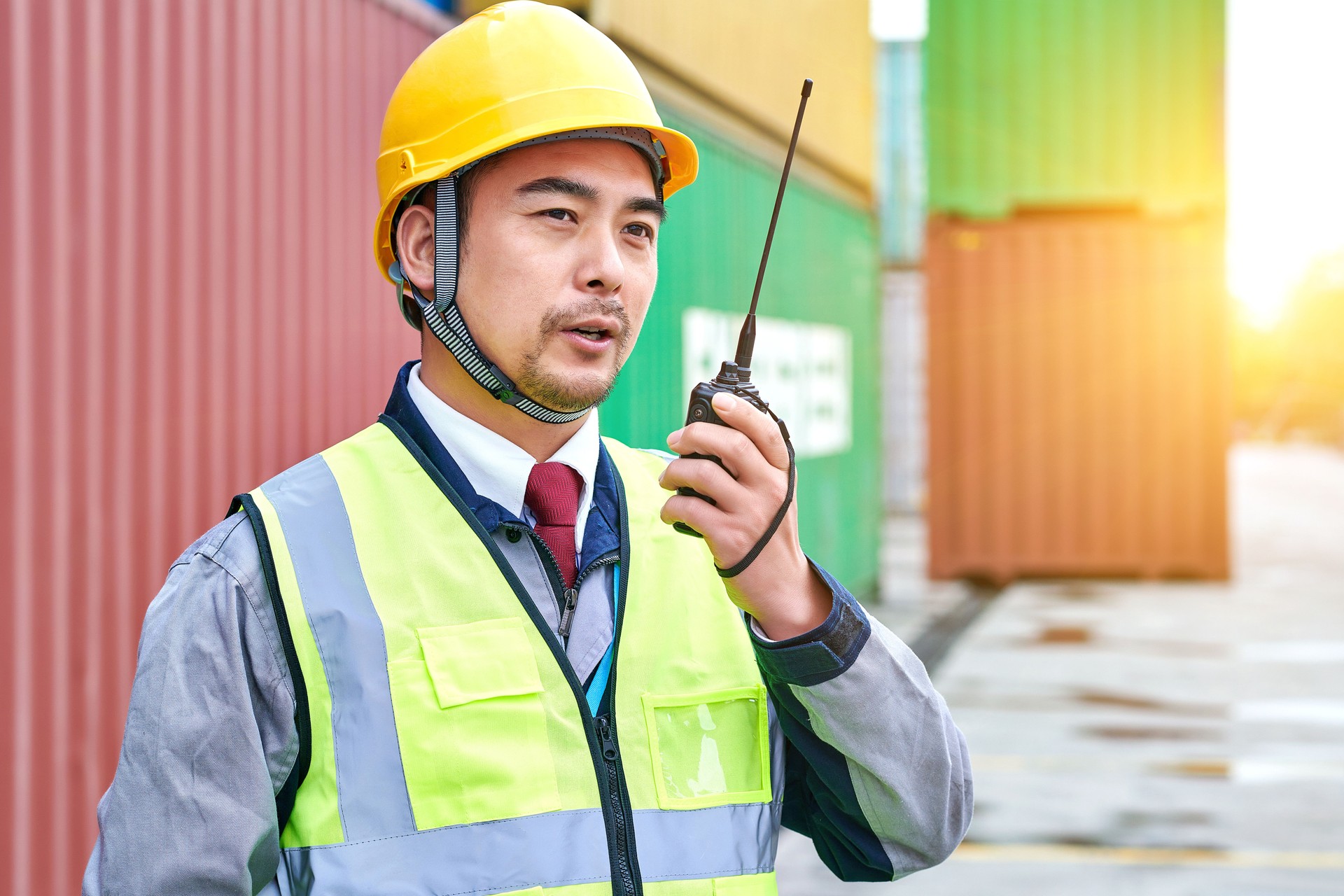 One Asian Worker Using Walkie-talkie at Commercial Dock
